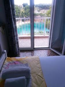 a bedroom with a view of a pool from a window at Magdalini in Votsi