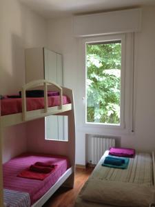 1 Schlafzimmer mit 2 Etagenbetten und einem Fenster in der Unterkunft Corner Apartment in Bologna