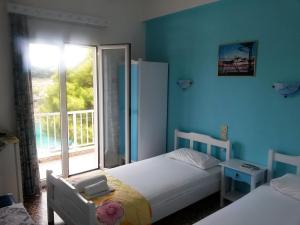 a bedroom with two beds and a window at Magdalini in Votsi