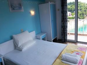 a bedroom with a white bed and a large window at Magdalini in Votsi +26 photos