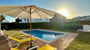 a pool with chairs and an umbrella next to a pool at Gemini by Check-in Portugal in Albufeira