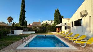 a swimming pool with lounge chairs next to a house at Gemini by Check-in Portugal in Albufeira +24 photos