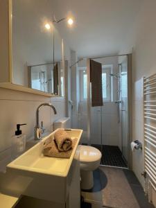 a white bathroom with a sink and a toilet at Bi Jöns in St. Peter-Ording