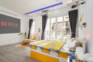 a bedroom with a yellow and white bed and a window at Happy house studio in Ho Chi Minh City