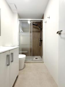 ein weißes Badezimmer mit Dusche und Toilette in der Unterkunft Habitación individual acogedora in Alicante
