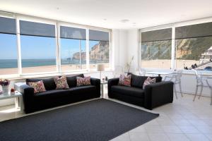 a living room with a couch and a view of the beach at Hotel Mar Bravo in Nazaré