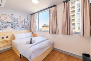 a bed in a room with a large window at easyHotel Croydon in Croydon