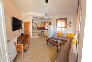 un salon avec un canapé et une table dans l'établissement Despoina's Maisonette at Rafaella Resort, à Kokóni