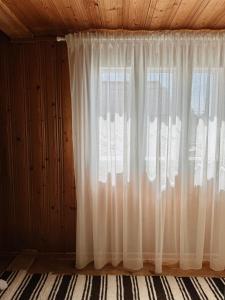 una ventana con cortinas blancas en una habitación en Bucovina reinterpretata cu suflet - A Heartfelt Take on Bucovina, en Vatra Moldoviţei 14 fotos más