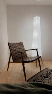 Una silla de ratán en una habitación con una lámpara. en Bucovina reinterpretata cu suflet - A Heartfelt Take on Bucovina, en Vatra Moldoviţei