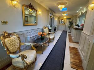 a hallway with chairs and a table and a mirror at Grand Central Hotel in Ó Méith