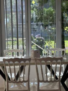 a table with white chairs and a large window at Hotel albatros shekvetili in Shekhvetili