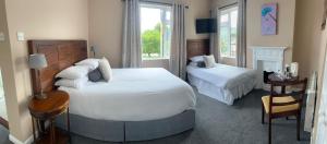 a bedroom with two beds and a table and a chair at Grand Central Hotel in Ó Méith