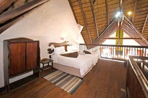 um quarto com uma cama e uma janela grande em Damani Lodge at Zebula Golf Estate and Spa em Warmbaths