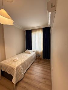 a small bedroom with a bed and a window at Seaview 2BR 2BA Apartment in Antalya Lara Cliffs in Antalya