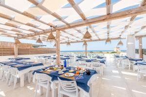 una sala per banchetti con tavoli e sedie e l'oceano di Baia Di Torre Squillace a Sant'Isidoro Altre 29 foto