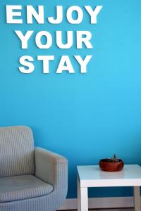 a chair and a table with a sign that says enjoy your stay at Hotel Mar Bravo in Nazaré