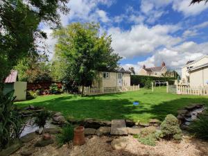 a yard with a stream in front of a house at Duck House - 1 Bed Shepherds Hut - Gower in Swansea