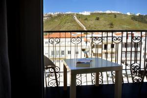 a table on a balcony with a view of a building at Hotel Mar Bravo in Nazaré