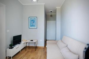 a living room with a white couch and a television at Aren Penthouse in Vlorë