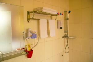 ein Badezimmer mit Dusche und Handtüchern an der Wand in der Unterkunft Notting Hill Hostel in Bao'an + 65 Fotos