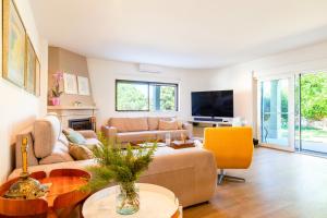 een woonkamer met een bank en een tv bij Villa Las Salinas by Algarve Vacation in Armação de Pêra