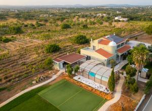 een luchtzicht op een huis met een tennisbaan bij Villa Las Salinas by Algarve Vacation in Armação de Pêra