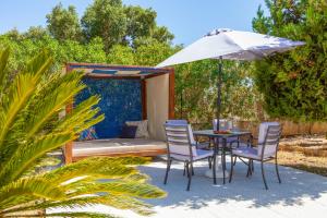 een terras met een tafel, stoelen en een parasol bij Villa Las Salinas by Algarve Vacation in Armação de Pêra