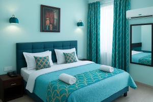 a blue bedroom with a bed and a mirror at Hotel Eurostar International By Quality Inn in New Delhi