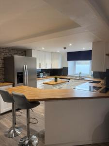 a kitchen with a wooden counter top and a refrigerator at Apartment 15 mins to Lake District & BAE Systems in Dalton in Furness