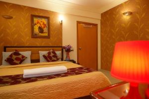 a hotel room with a bed and a red lamp at Hotel Eurostar International By Quality Inn in New Delhi