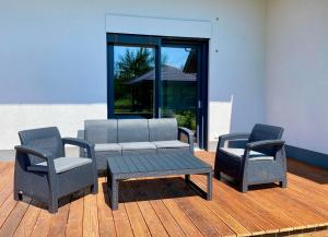 a patio with two chairs and a couch and a table at Zielona Ostoja - Pokoje i Apartamenty in Nowa Sarzyna