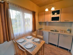 una cucina con tavolo in legno e piatti di Cottages near the sea for 2 people, Ustronie Morskie a Ustronie Morskie