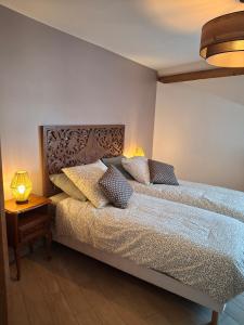 a bedroom with a bed with two lamps on it at Gîtes Ange et Bacchus in Villecresnes