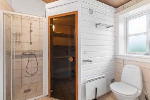 a bathroom with a toilet and a shower at Summer Cottage With Jacuzzi And Sauna in Fakse Ladeplads
