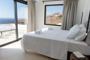 a bedroom with a white bed with a view of the ocean at Amazē Mykonos in Mikonos +45 photos