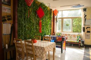 ein Esszimmer mit einem Tisch und einer grünen Wand in der Unterkunft Notting Hill Hostel in Bao'an
