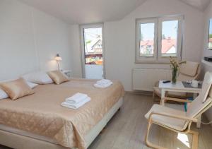 a bedroom with a bed and a table and chairs at Villa MB in Augustów