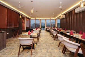 un restaurante con mesas y sillas con servilletas rojas. en ECKO Antarman On The Ganges, en Haridwar