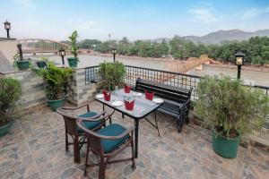 una mesa y sillas en un patio con vistas al río en ECKO Antarman On The Ganges, en Haridwar