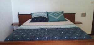 a bed with blue and white sheets and pillows at Micro-ferme agroécologique in Joyeuse