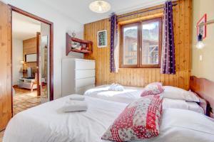 a bedroom with two beds and a window at Edelweiss in Morzine