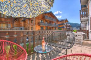 a table and chairs on a balcony with a house at Edelweiss in Morzine
