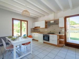 una cucina con un tavolo bianco e sedie in una stanza di Maison au bord du lac de Biscarrosse - 6 pers - Jardin et parking - Proche pistes cyclables - FR-1-319-511 a Biscarrosse Altre 21 foto