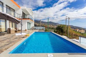 a swimming pool in the backyard of a house at Casa Teixeira by Atlantic Holiday in Estreito da Calheta