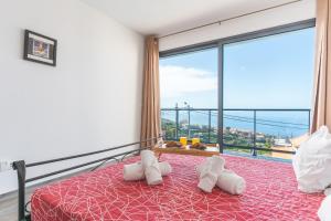 a bedroom with a bed and a large window at Casa Teixeira by Atlantic Holiday in Estreito da Calheta +25 photos