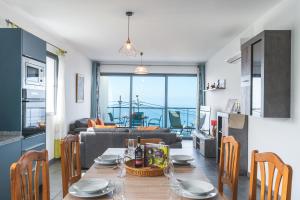 a kitchen and a living room with a table and chairs at Casa Teixeira by Atlantic Holiday in Estreito da Calheta