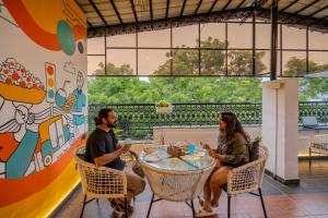 Un hombre y una mujer sentados en una mesa en un restaurante. en The Social Stays Bangalore formerly ArtBuzz, en Bangalore
