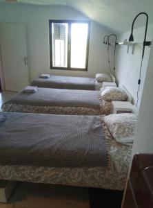 three beds in a room with a window at Panta rhei in Razvala