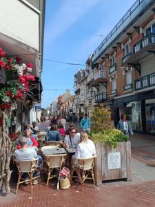 eine Gruppe von Menschen, die an Tischen auf einer Stadtstraße sitzen in der Unterkunft Centre ville Le Touquet, Villa familiale Villa familiale 3 grandes chambres, terrasse, intimité et Confort in Le Touquet-Paris-Plage